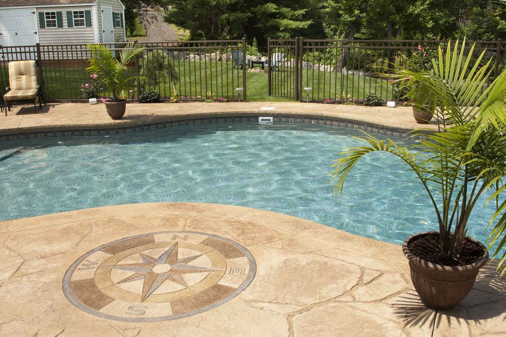 Mid-sized traditional backyard pool in Boston with stamped concrete.