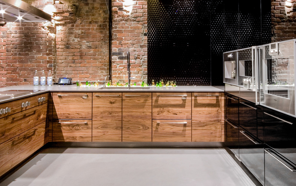 Inspiration for a large industrial u-shaped open plan kitchen in Vancouver with an undermount sink, flat-panel cabinets, medium wood cabinets, stainless steel appliances, concrete benchtops, black splashback, ceramic splashback, concrete floors and a peninsula.