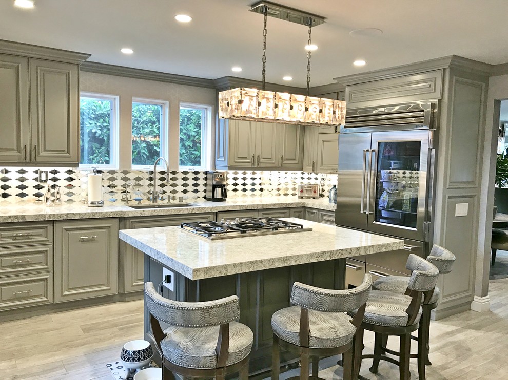Design ideas for a large transitional l-shaped separate kitchen in San Diego with an undermount sink, raised-panel cabinets, grey cabinets, granite benchtops, white splashback, ceramic splashback, stainless steel appliances, vinyl floors, multiple islands and grey floor.