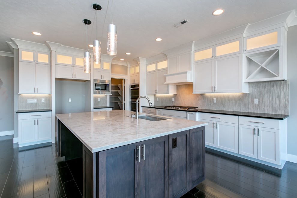 Large transitional l-shaped dark wood floor open concept kitchen photo in Seattle with an undermount sink, shaker cabinets, white cabinets, quartz countertops, gray backsplash, porcelain backsplash, stainless steel appliances, an island and white countertops
