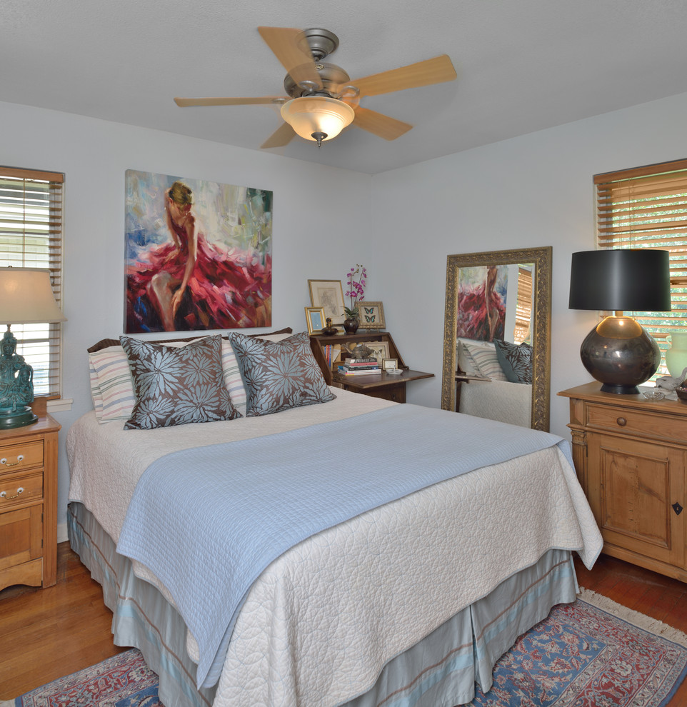 Design ideas for an eclectic bedroom in Houston with blue walls and medium hardwood floors.