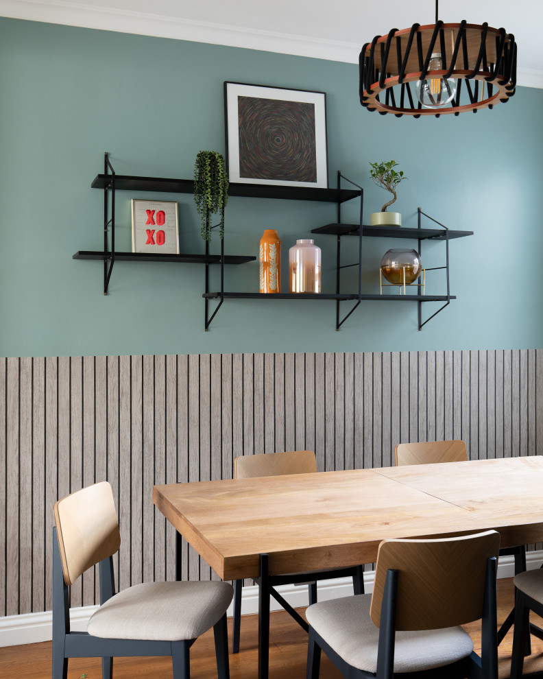 Bild på en mellanstor funkis matplats, med blå väggar, mellanmörkt trägolv och brunt golv