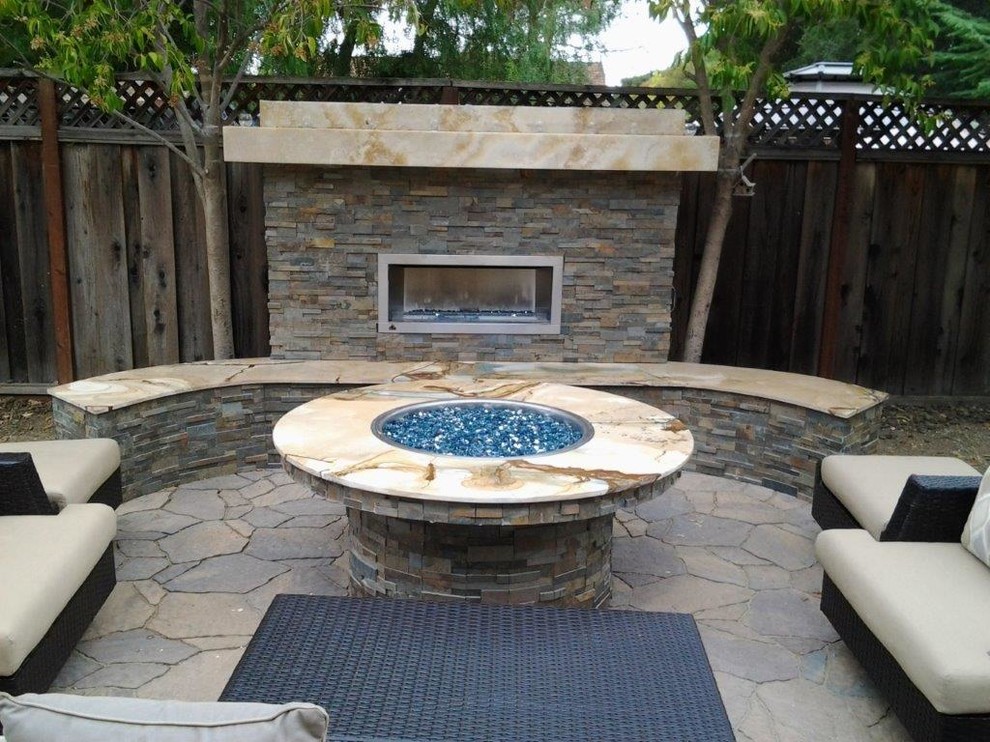 Photo of a small contemporary backyard patio in San Francisco with with fireplace, natural stone pavers and no cover.
