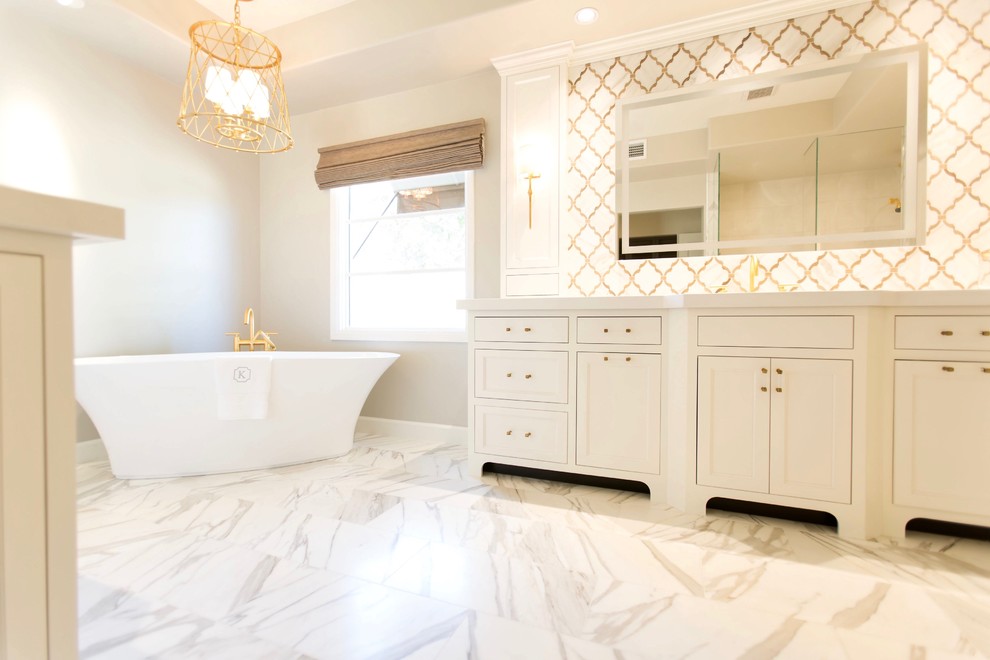 Inspiration for a transitional master white tile and stone tile marble floor freestanding bathtub remodel in Phoenix with recessed-panel cabinets, white cabinets, gray walls, an undermount sink and quartz countertops