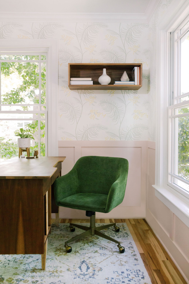 Klassisches Arbeitszimmer mit hellem Holzboden, braunem Boden, vertäfelten Wänden und bunten Wänden in Austin