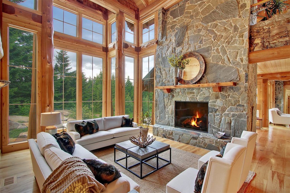 Inspiration for a large country formal open concept living room in Seattle with brown walls, light hardwood floors, a stone fireplace surround and no tv.