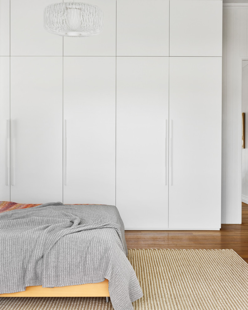 Idee per una camera degli ospiti contemporanea di medie dimensioni con pareti bianche, parquet chiaro, pavimento marrone, soffitto a volta e boiserie