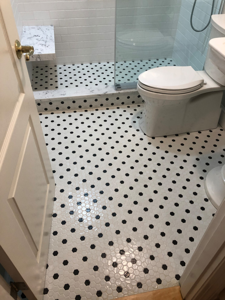 This is an example of a mid-sized transitional 3/4 bathroom in Boston with an alcove shower, a two-piece toilet, black and white tile, ceramic tile, grey walls, mosaic tile floors, a pedestal sink, black floor and a sliding shower screen.