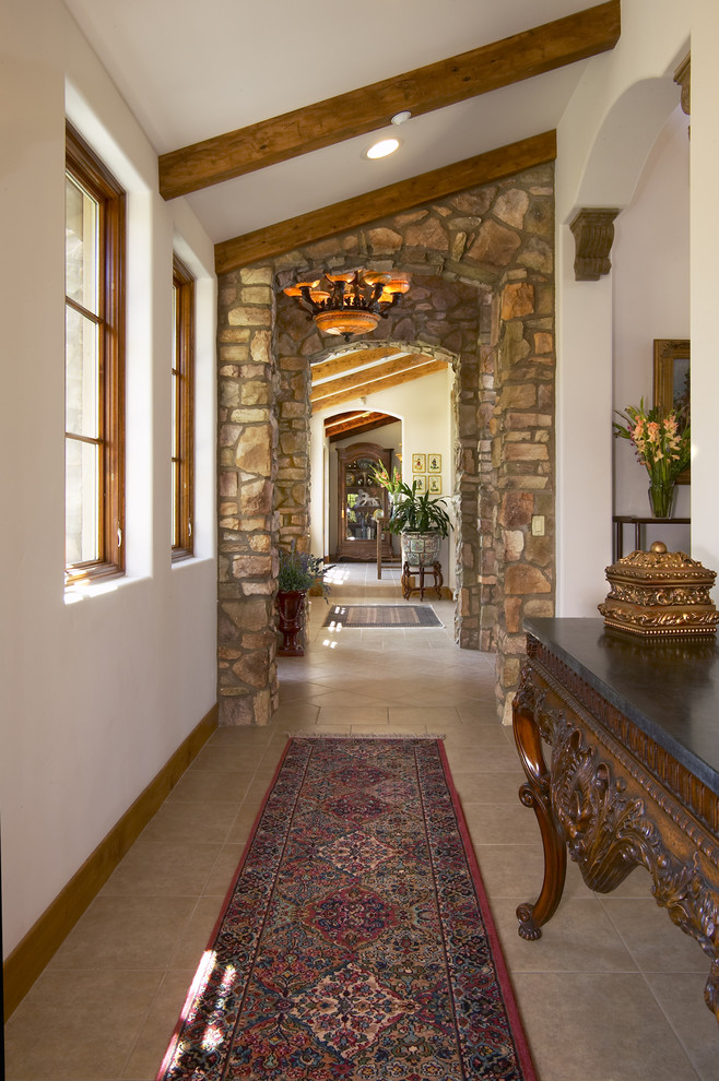 Design ideas for a mediterranean hallway in San Diego with white walls and limestone floors.