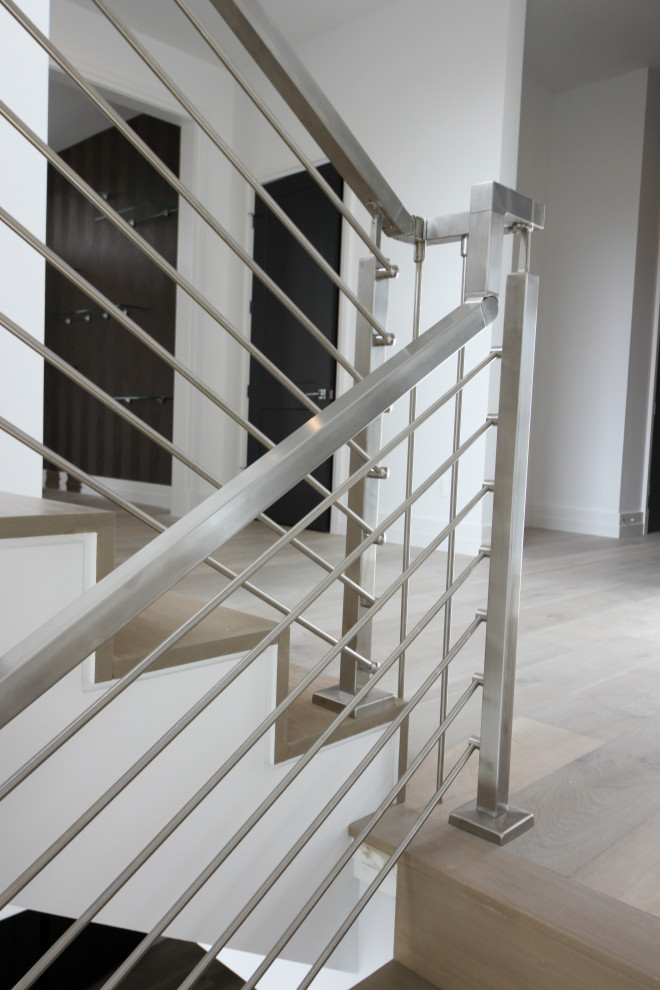 Foto de escalera suspendida moderna de tamaño medio con escalones de madera, contrahuellas de madera, barandilla de metal y machihembrado