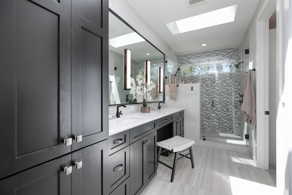 Design ideas for an expansive transitional master bathroom in Portland with shaker cabinets, black cabinets, an alcove shower, a one-piece toilet, black and white tile, porcelain tile, white walls, porcelain floors, a drop-in sink, engineered quartz benchtops, grey floor, a hinged shower door, white benchtops, a shower seat, a double vanity and a built-in vanity.