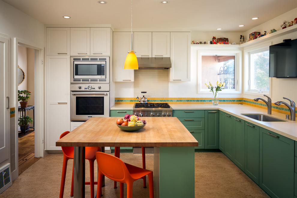 Mid-sized contemporary l-shaped kitchen pantry in San Francisco with an undermount sink, shaker cabinets, green cabinets, quartz benchtops, orange splashback, ceramic splashback, stainless steel appliances, linoleum floors, with island and brown floor.
