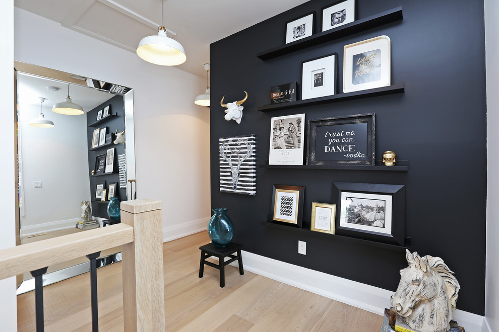 Inspiration for a mid-sized scandinavian light wood floor hallway remodel in Toronto with black walls