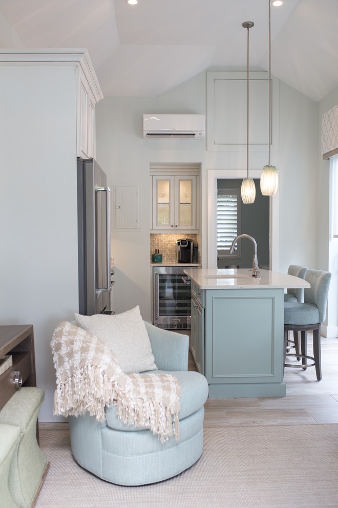 Example of a mid-sized transitional l-shaped light wood floor and beige floor open concept kitchen design in Miami with an undermount sink, recessed-panel cabinets, blue cabinets, quartz countertops, beige backsplash, mosaic tile backsplash, stainless steel appliances and an island