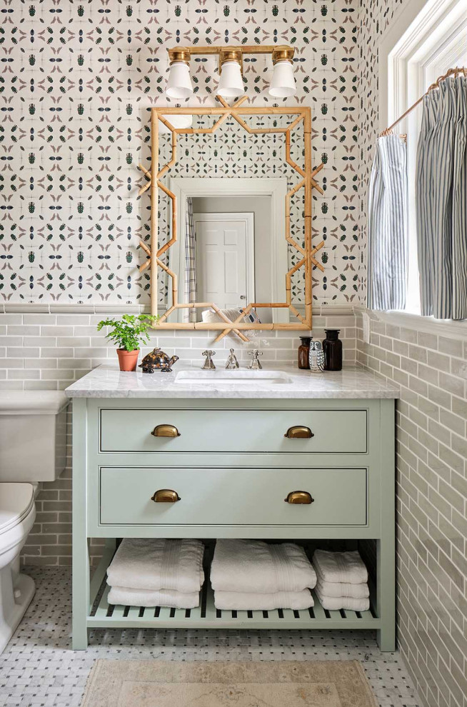 Cette image montre une salle de bain traditionnelle pour enfant avec des portes de placards vertess, un plan de toilette en marbre et du papier peint.