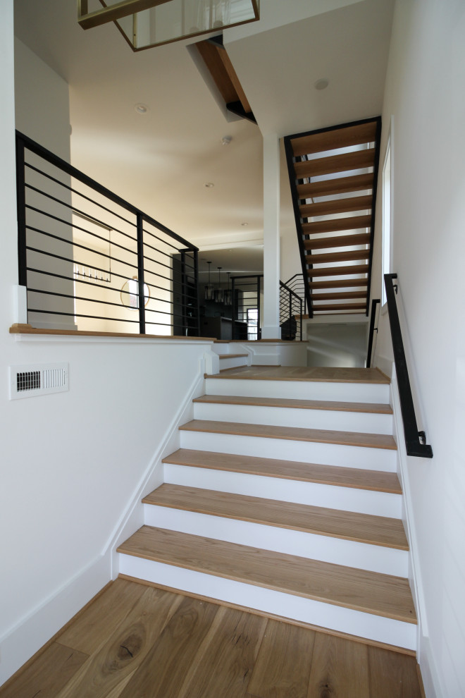 Cette photo montre un escalier droit tendance de taille moyenne avec des marches en bois et un garde-corps en métal.