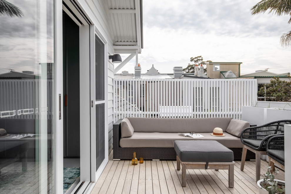 Photo of a small contemporary balcony in Sydney with with privacy feature, no cover and wood railing.