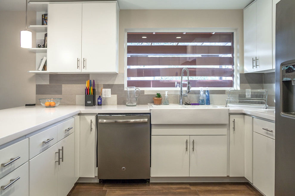 Open concept kitchen - transitional u-shaped porcelain tile open concept kitchen idea in Phoenix with a farmhouse sink, shaker cabinets, white cabinets, quartz countertops, multicolored backsplash, porcelain backsplash, stainless steel appliances and an island