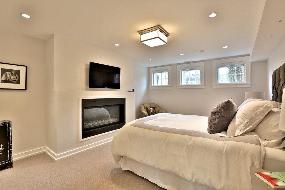 Photo of a large contemporary master bedroom in Toronto with white walls, carpet, a hanging fireplace and a plaster fireplace surround.