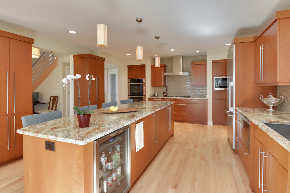 This is an example of a large contemporary u-shaped eat-in kitchen in Milwaukee with an undermount sink, flat-panel cabinets, medium wood cabinets, beige splashback, matchstick tile splashback, stainless steel appliances, light hardwood floors, with island, brown floor and multi-coloured benchtop.