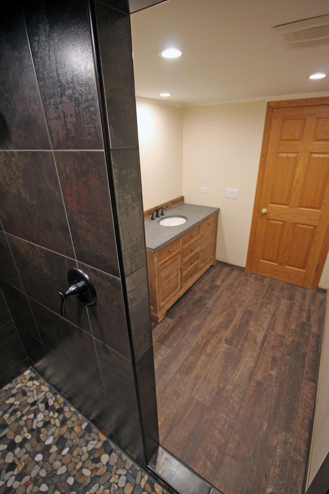 Large contemporary 3/4 wet room bathroom in Chicago with louvered cabinets, light wood cabinets, multi-coloured tile, porcelain floors, an undermount sink, soapstone benchtops, brown floor, a two-piece toilet, ceramic tile, beige walls, an open shower and black benchtops.