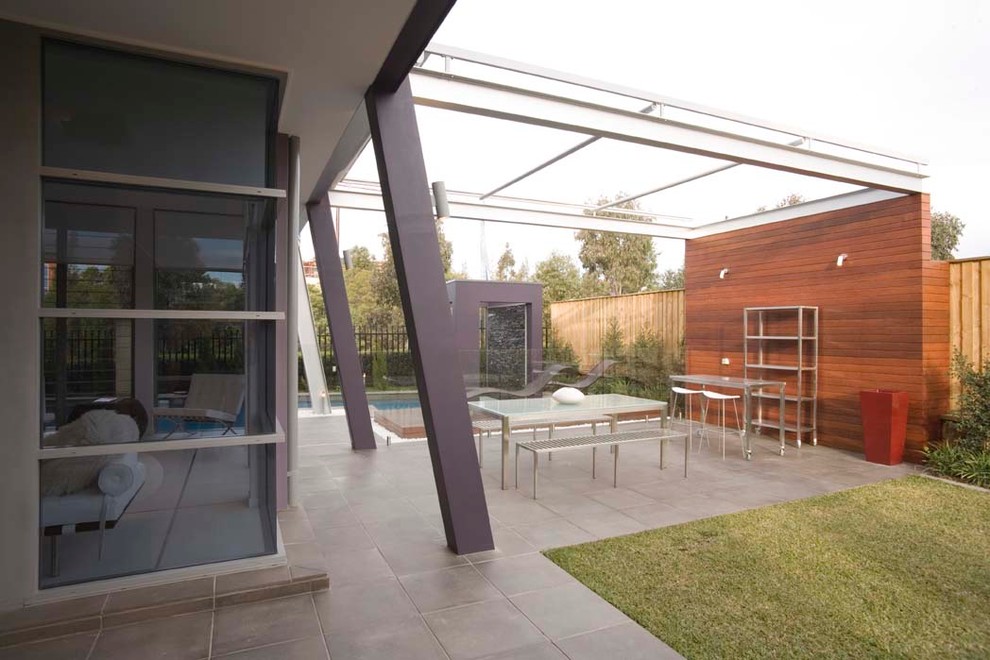 Photo of a mid-sized contemporary backyard patio in Sydney with concrete pavers and a pergola.