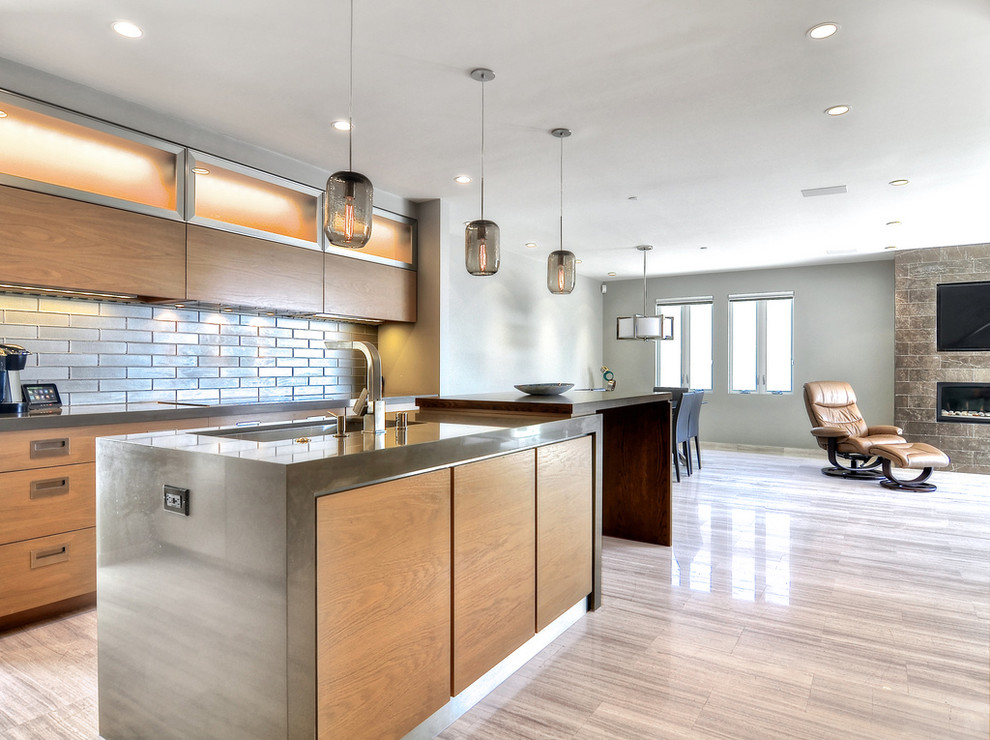 Photo of a large modern l-shaped open plan kitchen in San Francisco with an undermount sink, flat-panel cabinets, light wood cabinets, zinc benchtops, metallic splashback, metal splashback, stainless steel appliances, ceramic floors, with island and beige floor.