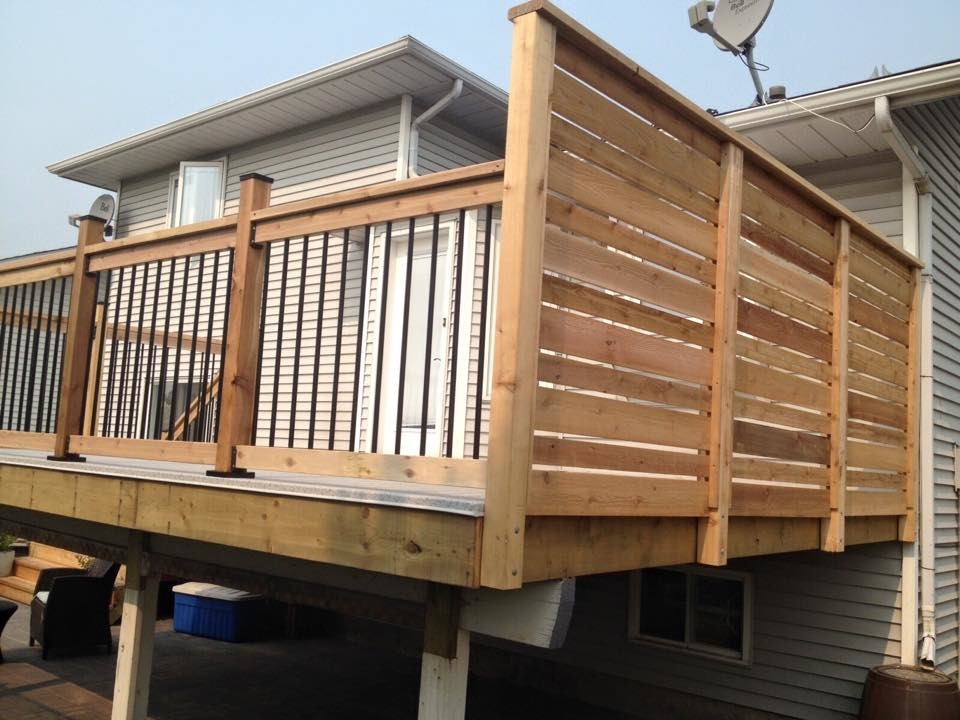 Example of a mid-sized transitional backyard deck design in Calgary with no cover