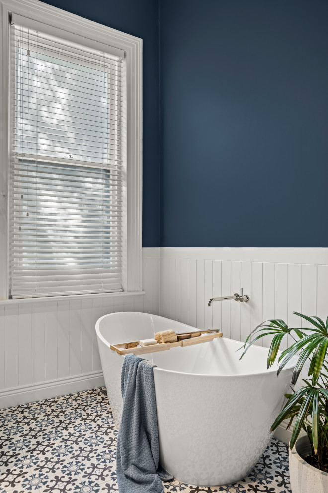 На фото: большая ванная комната в классическом стиле с фасадами в стиле шейкер, белыми фасадами, отдельно стоящей ванной, синей плиткой, керамической плиткой, синими стенами, полом из керамогранита, душевой кабиной, столешницей из искусственного кварца, синим полом, белой столешницей, тумбой под две раковины, напольной тумбой и панелями на части стены с