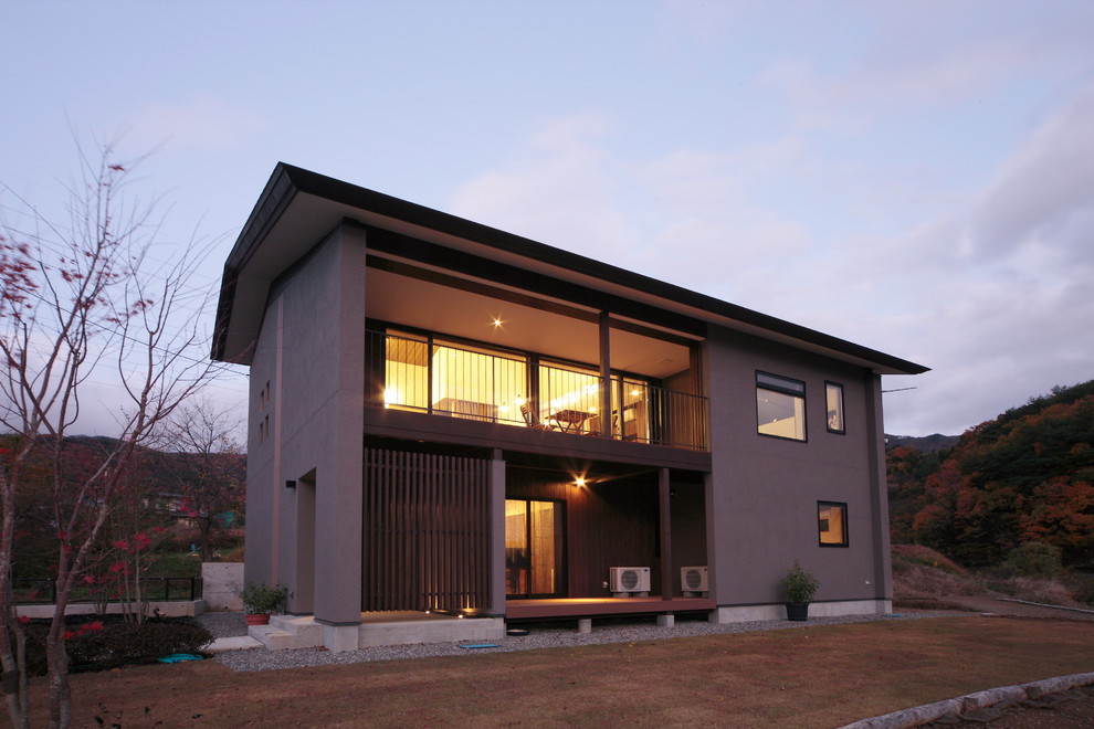 Photo of a contemporary two-storey grey house exterior in Other with mixed siding, a gable roof and a metal roof.