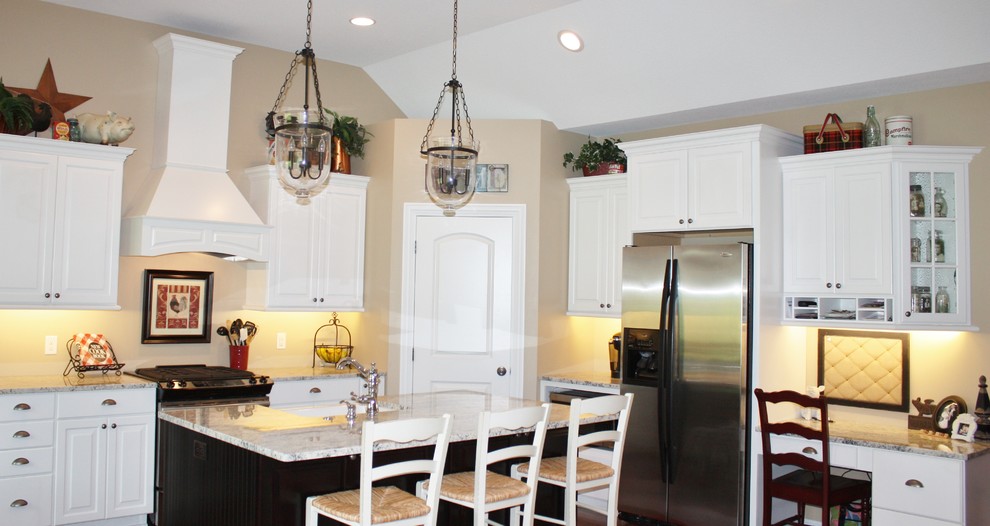 Transitional kitchen photo in Minneapolis with a farmhouse sink, white cabinets, stainless steel appliances and an island