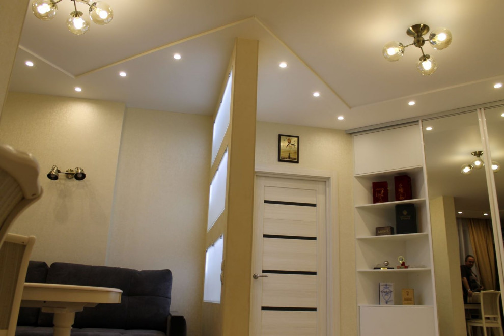 Idéer för ett litet klassiskt vardagsrum, med ett bibliotek, beige väggar, laminatgolv, en väggmonterad TV och beiget golv