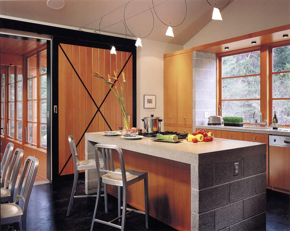 Country kitchen in Seattle with flat-panel cabinets, light wood cabinets and panelled appliances.