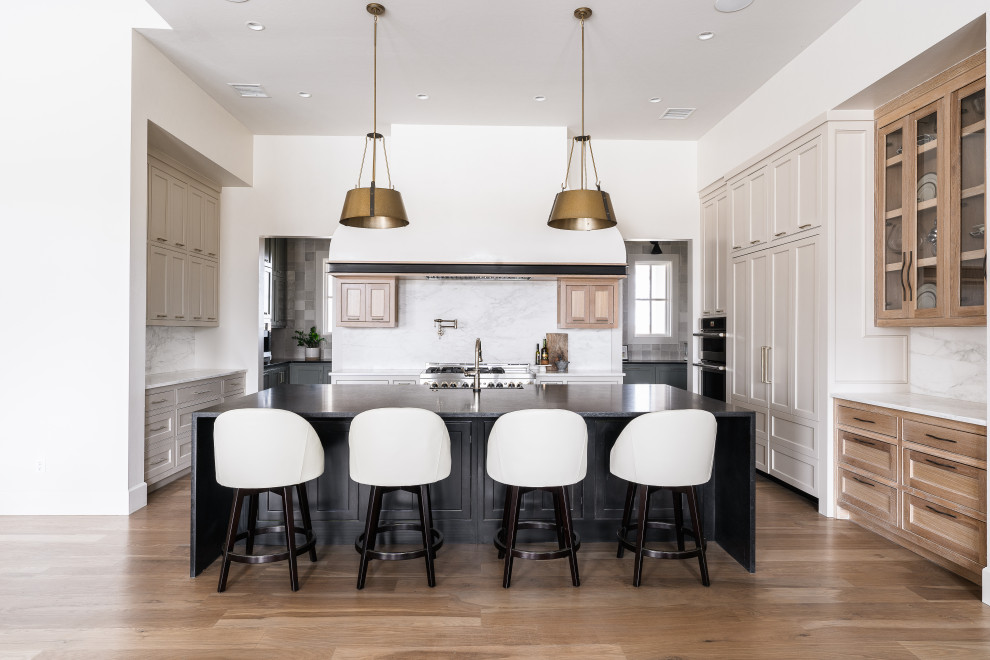 Design ideas for a large transitional u-shaped open plan kitchen in Oklahoma City with recessed-panel cabinets, light wood cabinets, marble benchtops, white splashback, marble splashback, stainless steel appliances, medium hardwood floors and with island.