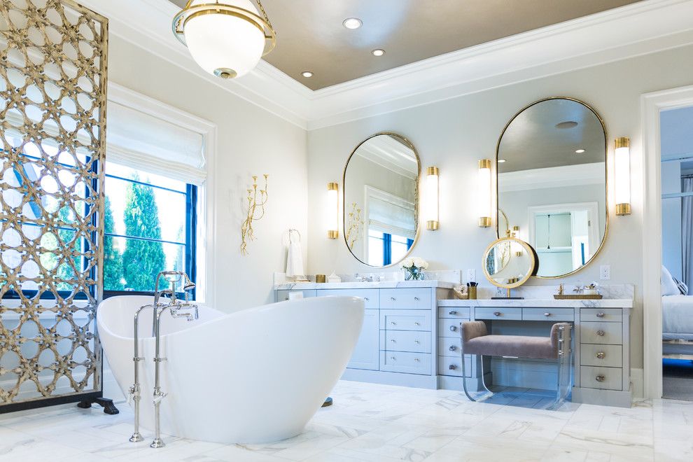 This is an example of a large contemporary master bathroom in Salt Lake City with grey walls, marble floors, white floor, flat-panel cabinets, grey cabinets, a freestanding tub, an undermount sink and marble benchtops.
