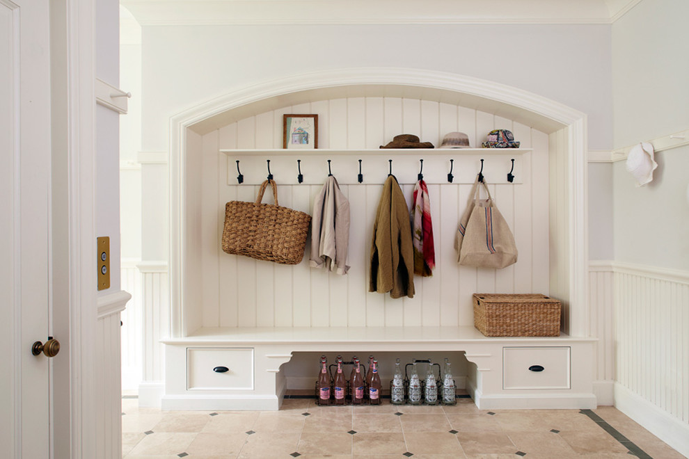 This is an example of a traditional mudroom in Other with white walls and beige floor.