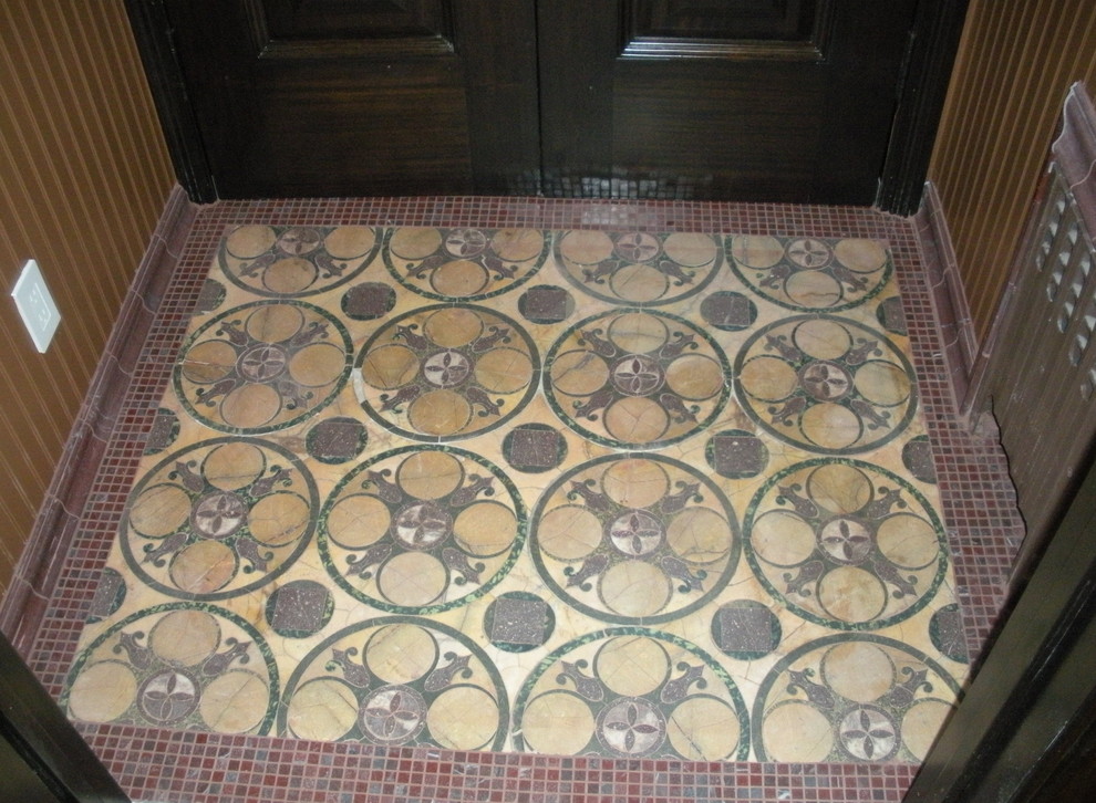 This is an example of a small transitional vestibule in New York with beige walls, porcelain floors, a double front door and a dark wood front door.