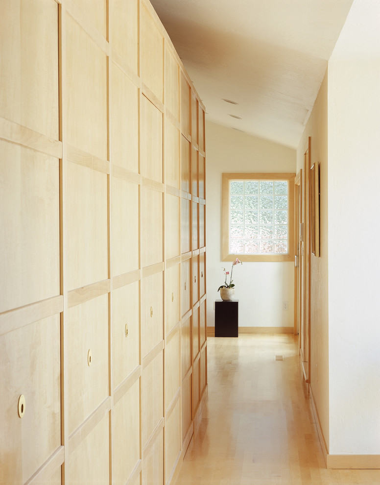 Design ideas for an asian hallway in San Francisco with white walls and light hardwood floors.