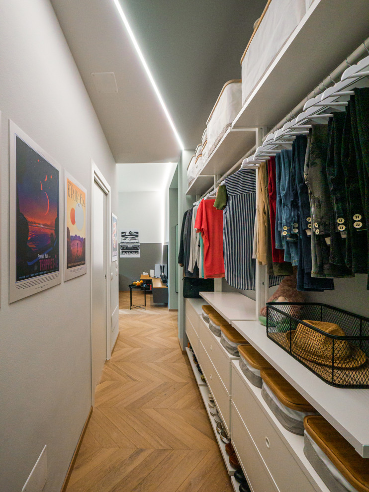 Mid-sized industrial storage and wardrobe in Milan with light hardwood floors and recessed.