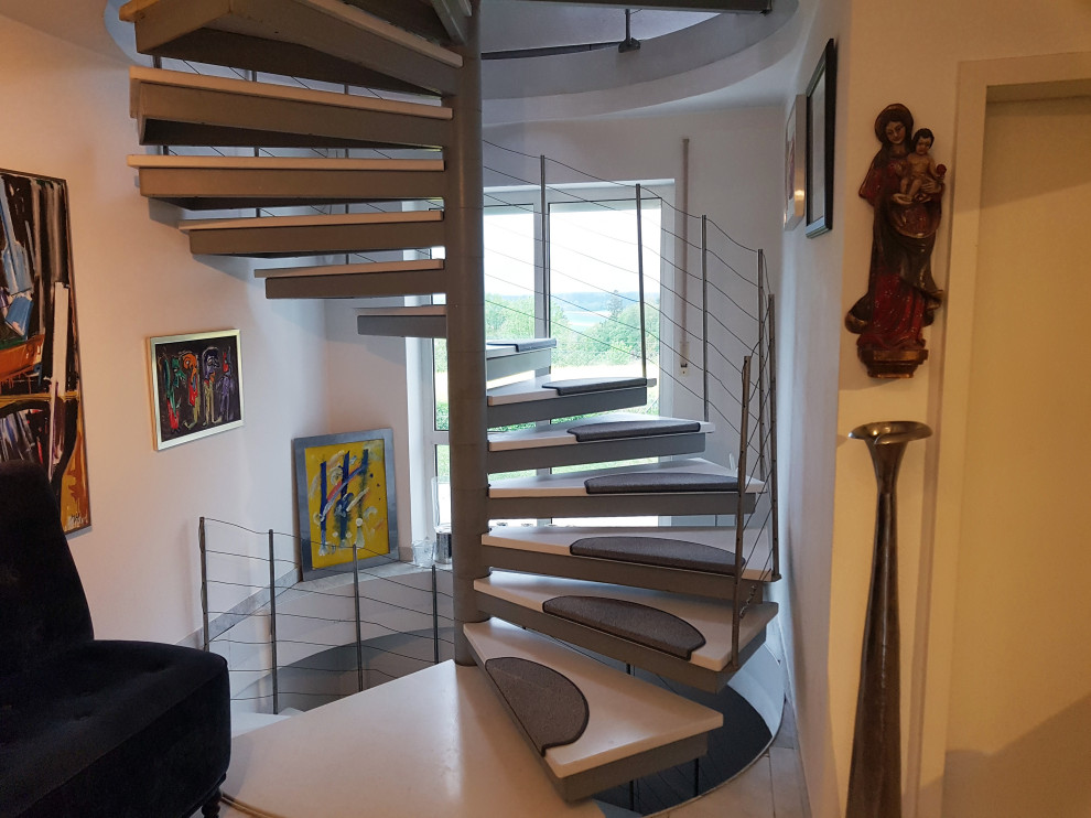 Große Moderne Treppe mit Metall-Setzstufen, Stahlgeländer und Ziegelwänden in München