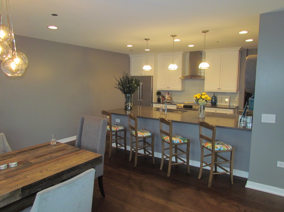 Open concept kitchen - large transitional l-shaped medium tone wood floor open concept kitchen idea in Chicago with a single-bowl sink, shaker cabinets, white cabinets, quartz countertops, green backsplash, glass tile backsplash, white appliances and a peninsula