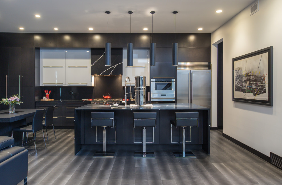 This is an example of a contemporary single-wall kitchen/diner in Other with a submerged sink, flat-panel cabinets, black cabinets, engineered stone countertops, black splashback, ceramic splashback, stainless steel appliances, dark hardwood flooring, an island, grey floors and black worktops.