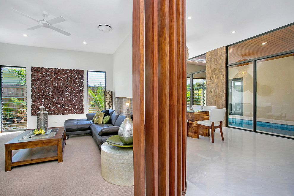 This is an example of a mid-sized tropical enclosed family room in Cairns with carpet and no tv.