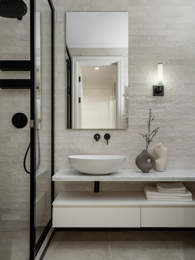 Idées déco pour une salle de bain contemporaine avec des portes de placard beiges, un plan de toilette en marbre, un plan de toilette blanc, meuble-lavabo suspendu, un espace douche bain, un mur beige, une vasque et une cabine de douche à porte battante.