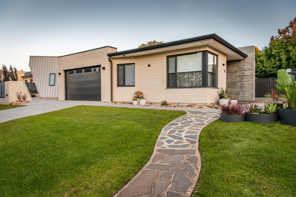 Mid-sized midcentury one-storey brick multi-coloured house exterior in Adelaide with a hip roof and a metal roof.