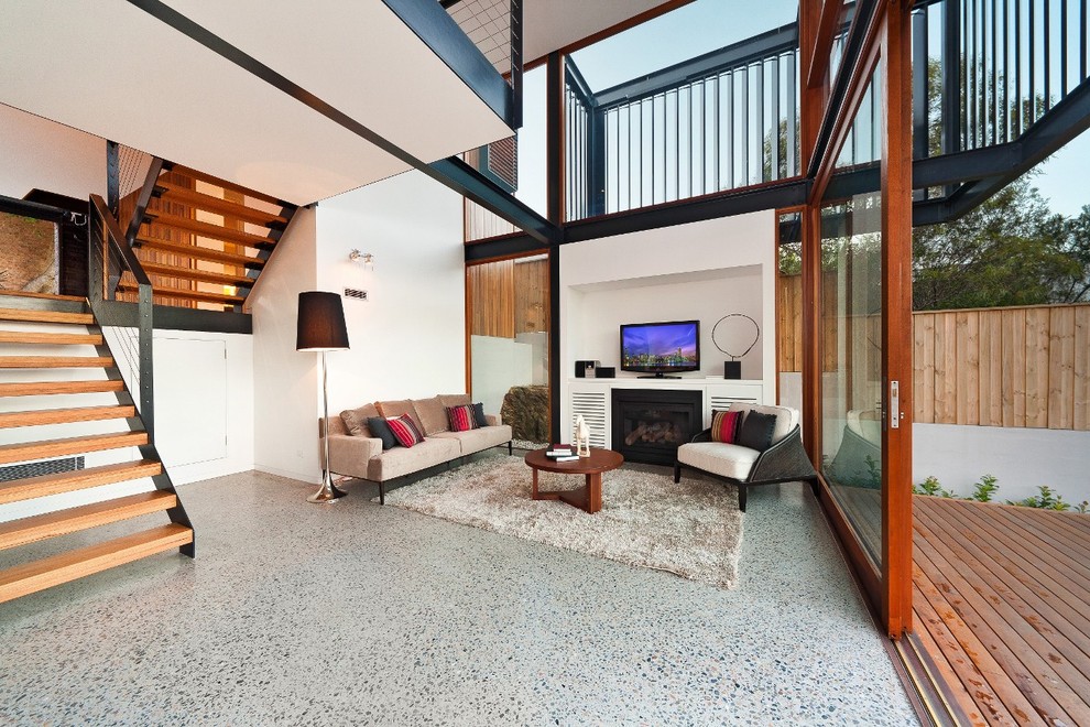 This is an example of a large open concept living room in Sydney with a home bar, white walls, concrete floors and a freestanding tv.