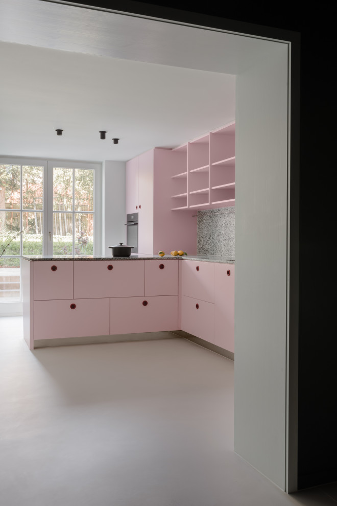 Идея дизайна: огромная угловая кухня в современном стиле с врезной мойкой, плоскими фасадами, розовыми фасадами, столешницей терраццо, серым фартуком, черной техникой, полуостровом, серым полом и серой столешницей