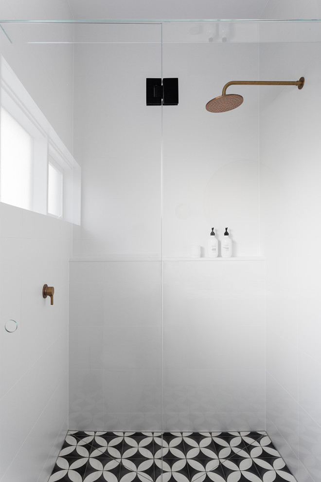 Design ideas for a large contemporary master bathroom in Melbourne with flat-panel cabinets, light wood cabinets, a freestanding tub, an alcove shower, a one-piece toilet, cement tile, cement tiles, an integrated sink, marble benchtops and black floor.