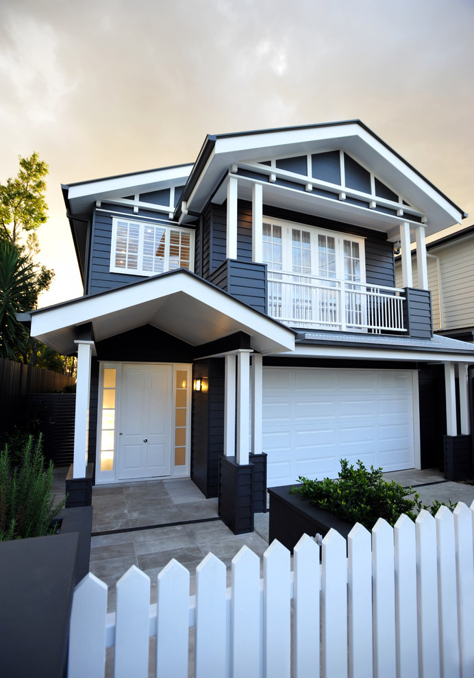 This is an example of a traditional two-storey black house exterior in Brisbane with wood siding and a gable roof.