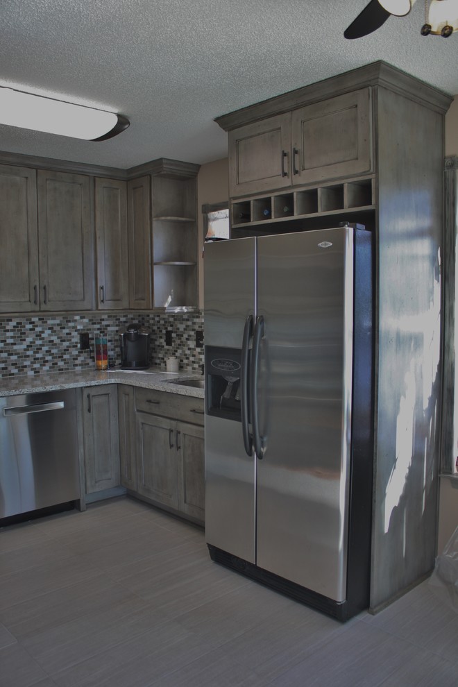 Small transitional u-shaped ceramic tile kitchen photo in Charlotte with no island, flat-panel cabinets, distressed cabinets, granite countertops, gray backsplash, mosaic tile backsplash, stainless steel appliances and an undermount sink
